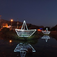 Μεταλλικές βάρκες φωτιζόμενες σε τεχνητή λίμνη